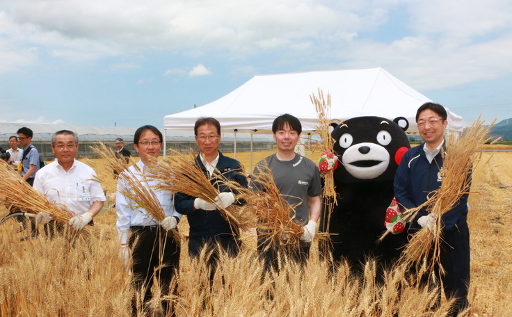収穫した小麦を手に写る市長たち