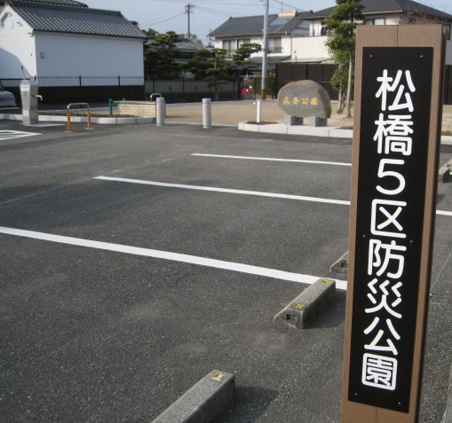 松橋5区防災公園と書かれた札が駐車場に立ててある写真