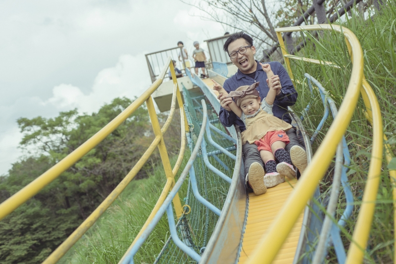 岡武公園のローラースライダーを一緒に滑っている親子の写真