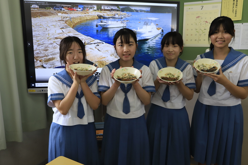 おかずの皿を持っている女子生徒の写真