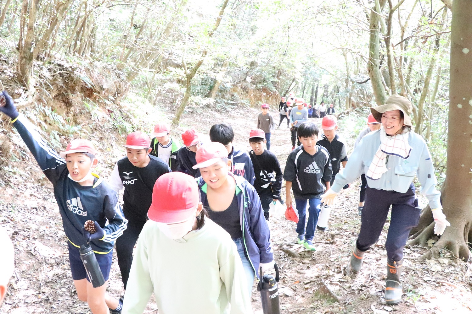 豊野小学校の児童たちが熊本県立豊野少年自然の家から会場までの遊歩道を元気に歩いている様子の写真