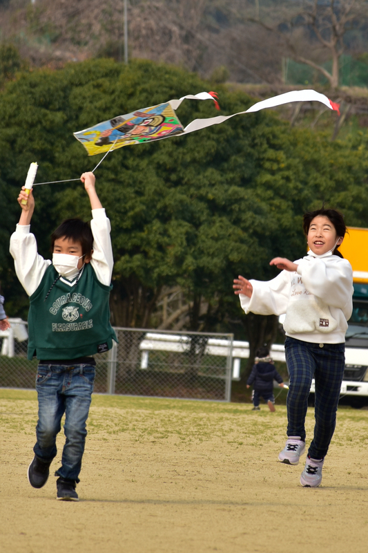 兄弟で凧揚げをしている写真