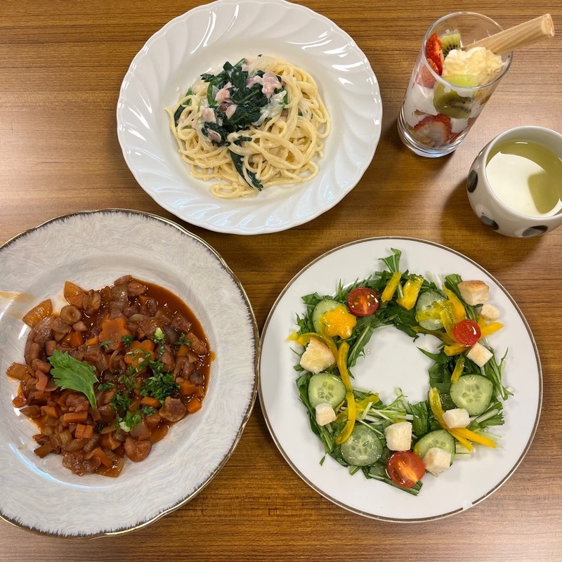 パスタや、色とりどりのサラダ、デザートなどの写真