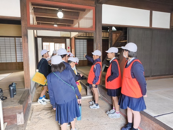 ビブスをつけた6年生が説明している様子