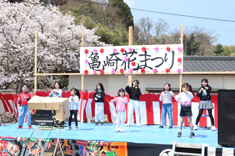 地区の子どもたちがステージでダンスを披露している写真