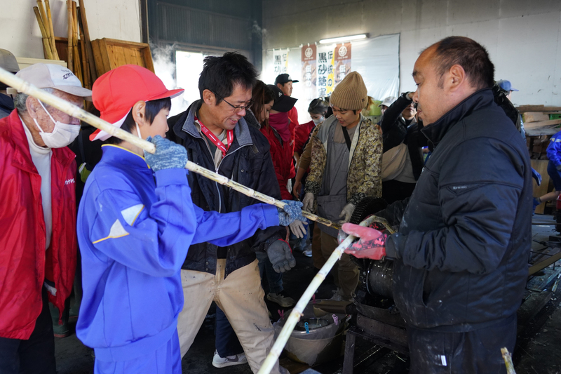 機械でサトウキビの汁を搾る様子