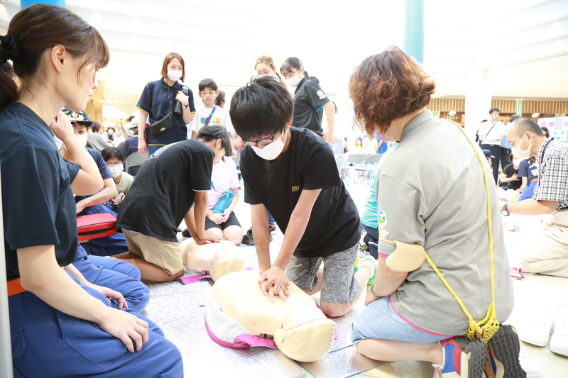 胸骨圧迫の指導を受ける様子