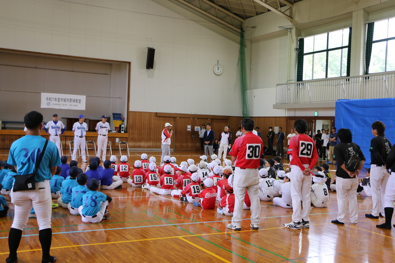 豊田さんによる野球教室開催の挨拶と、話を聞く子供たちの写真