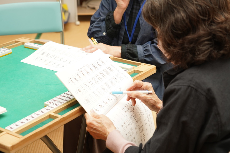 牌のイラストの描かれた資料を見ている様子