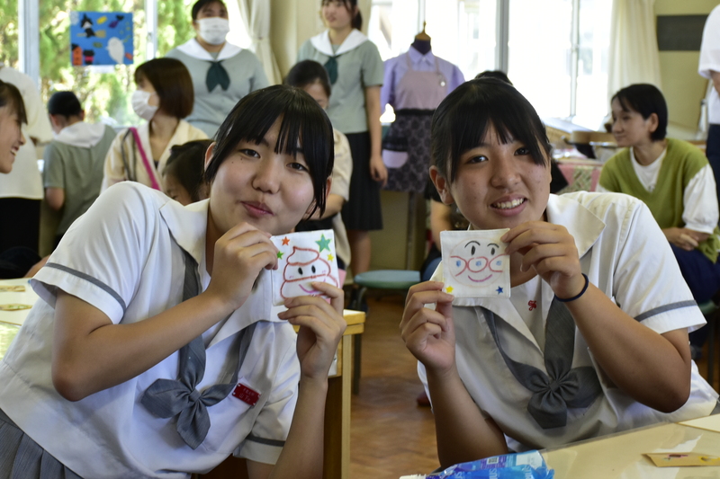 家政科で作成したコースターをカメラに向かって見せている様子
