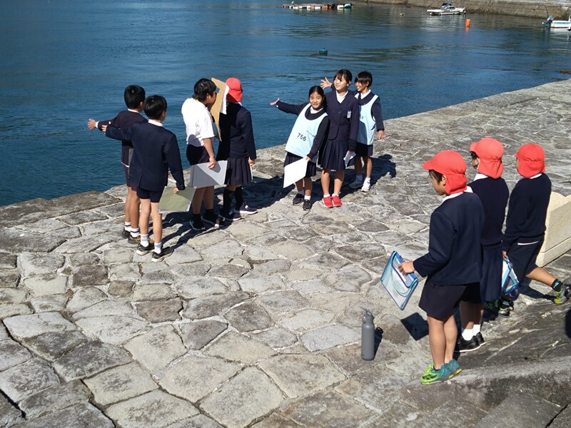 海を指しながら説明をする様子