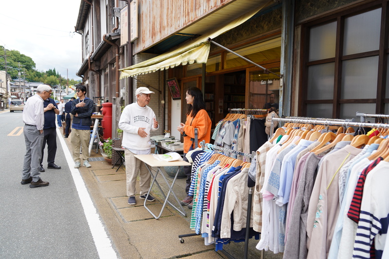 塩屋の店先で出店者と会話するお客さんの様子