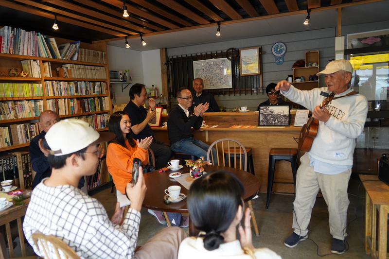 カフェでくつろぎながらギター演奏を聴く様子