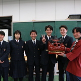 小川工業高校3年生の生徒が小川獅子組へ練習用の獅子頭を寄贈した様子の写真
