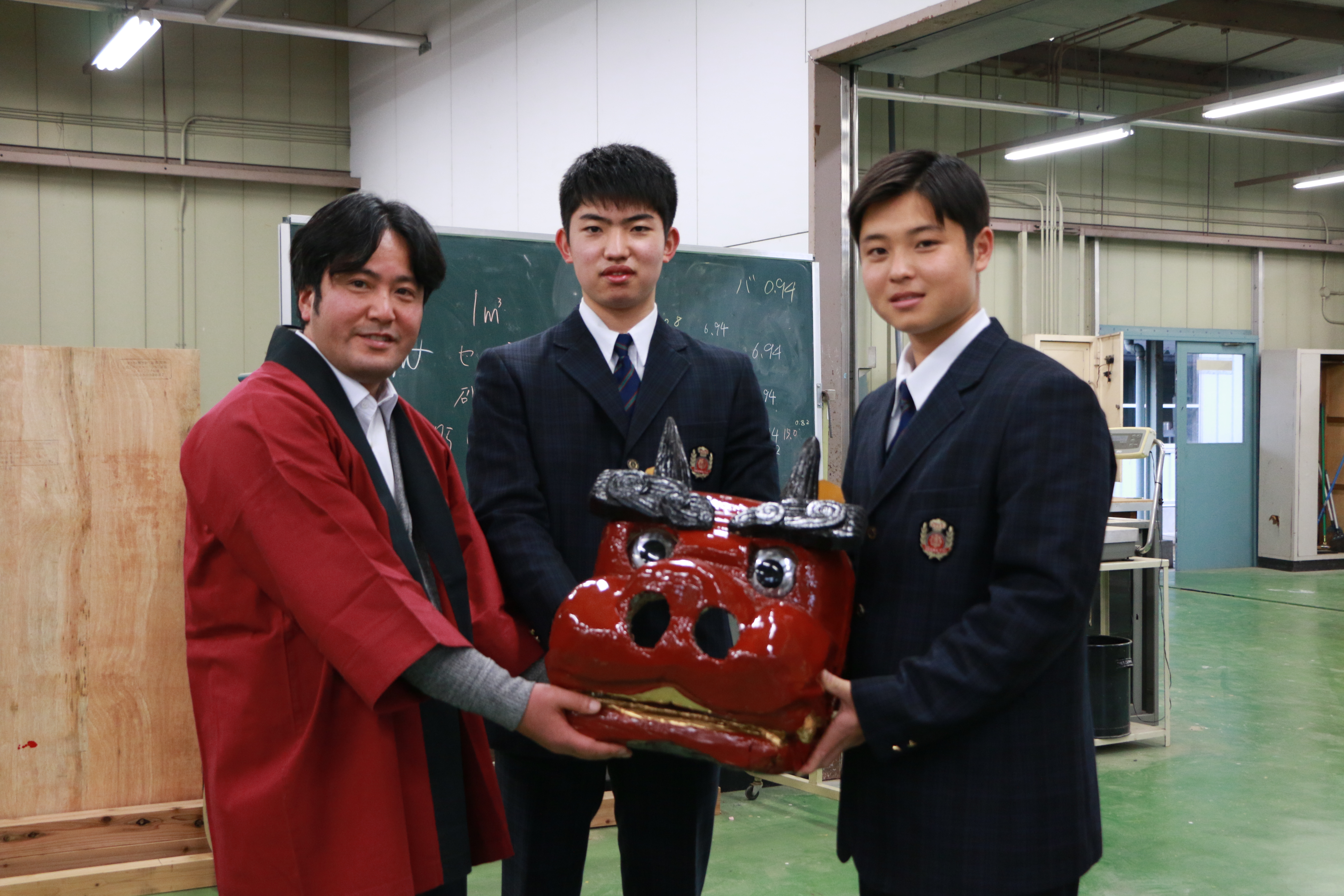 製作した獅子頭を寄贈している小川工業高校生と獅子組上町代表の写真