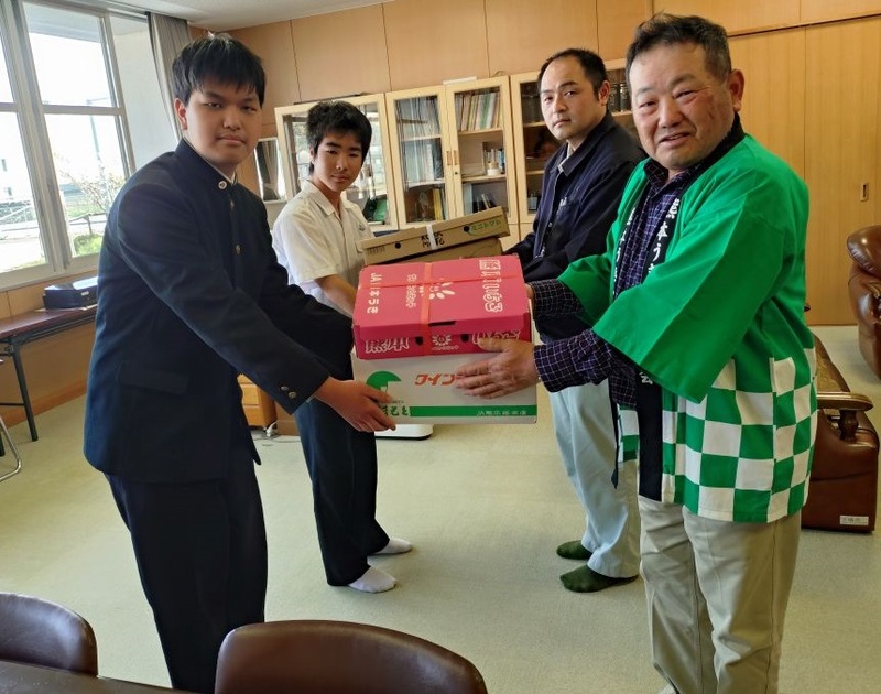 JA熊本うき園芸販売課福田さん、廻田誠部会長から佐藤耀陽さん、平野翼さんに野菜を贈呈する様子の写真